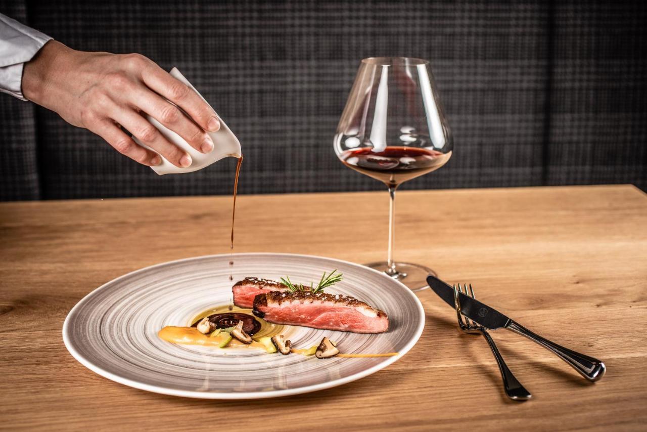 My Arbor - Dolomites Hotel Bressanone Exterior photo A server pouring sauce onto a prepared dish